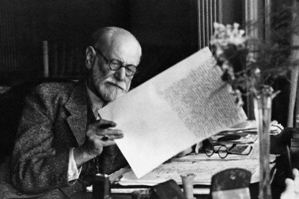 Photographie en noir et blanc de Sigmund Freud assis à son bureau